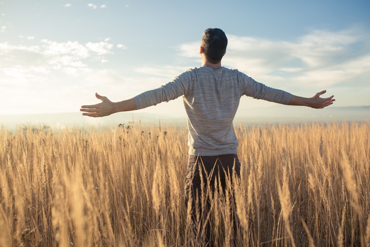 man in field decompressing from stress