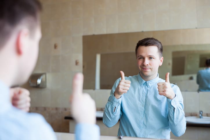 man saying self affirmations in mirror