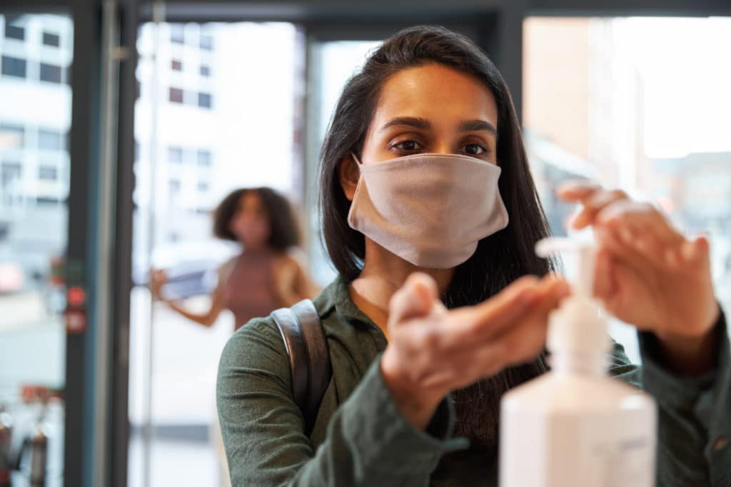 woman in business using hand sanitizer